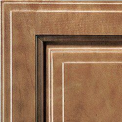 Close-up of a cabinet door corner with dark brown, bronze, and white layered details.