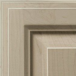 Close-up of a wooden cabinet door with a layered, rectangular design in shades of beige and tan.