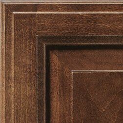 Close-up of a wooden cabinet door corner in shades of brown, featuring layered paneling and grain detail.