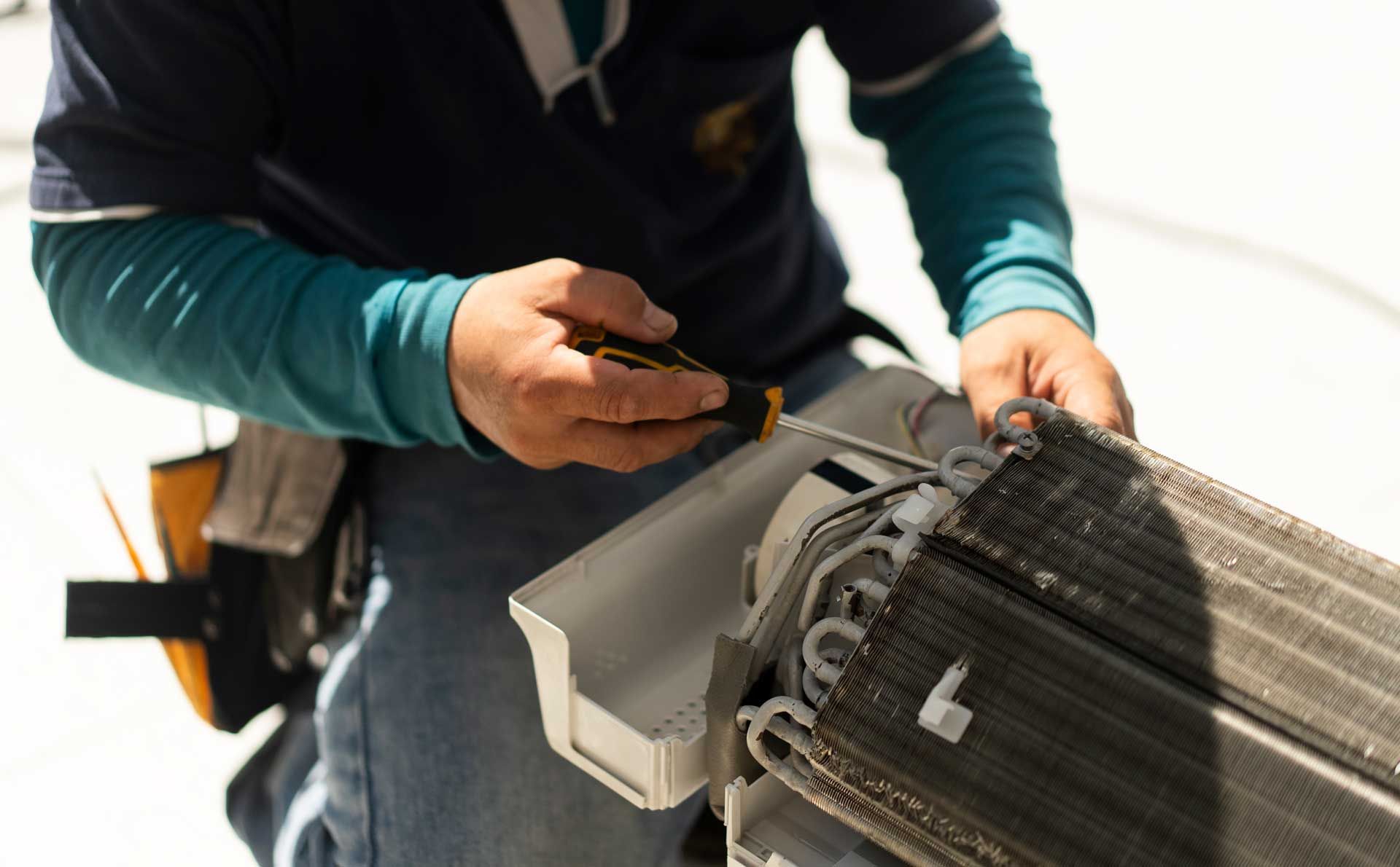A man is repairing an AC.