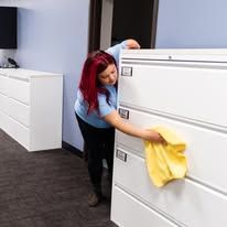 Picture of a woman cleaning an office.
