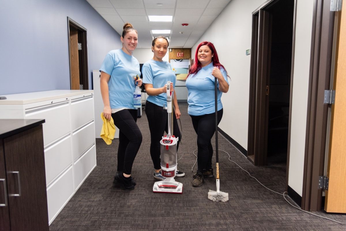 Picture of 3 team members of Clean Spaces LLC posing for the picture in a hallway. 