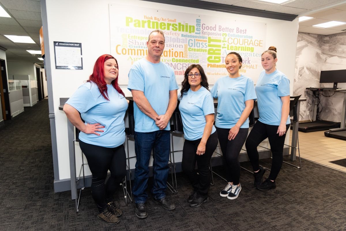 Picture of the team of clean spaces standing proudly in front of a white board. 