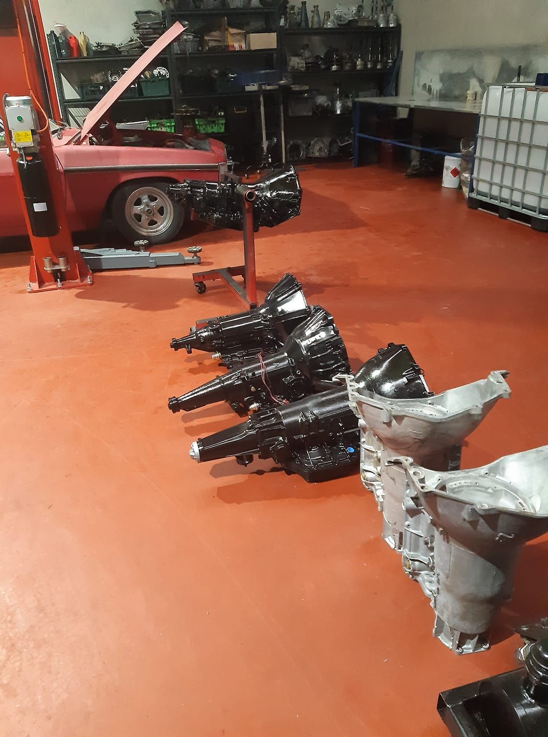A Red Car is Parked in a Garage Next to a Bunch of Gearboxes — Burko Transmissions in Shepparton, VIC