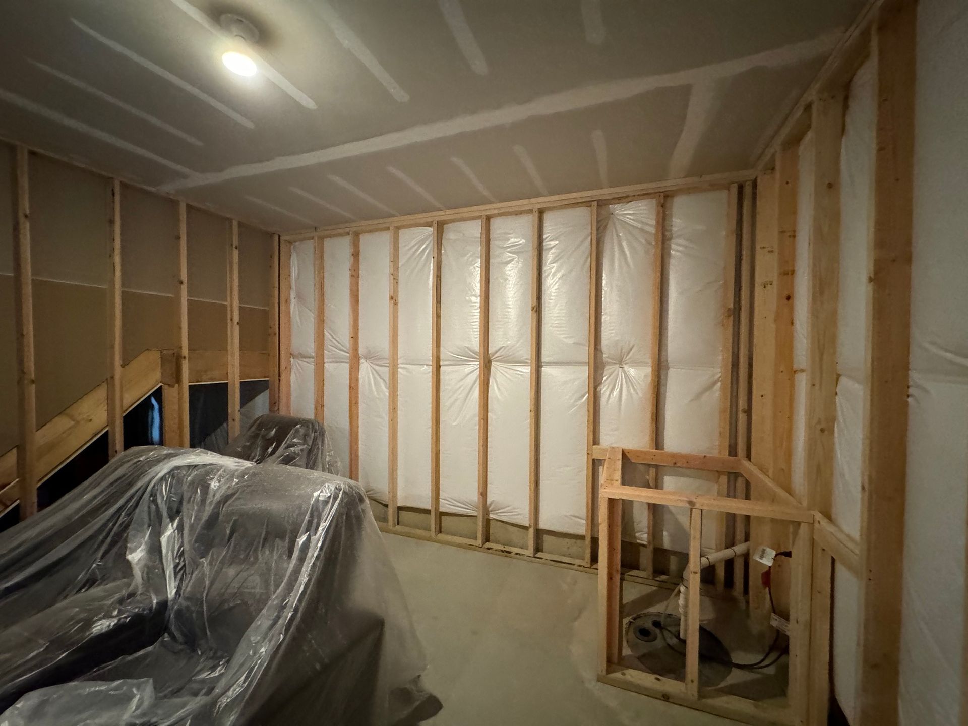 Interior framing of a room under construction with insulation in the walls.