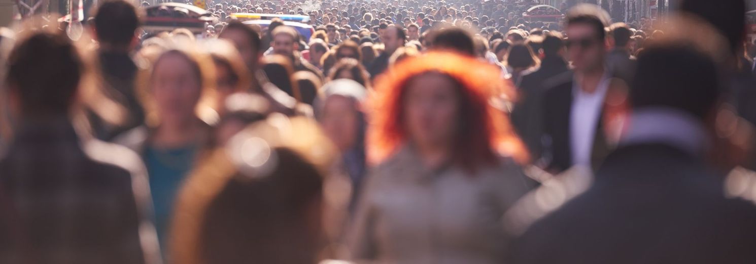 A blurry picture of a crowd of people walking down a street.