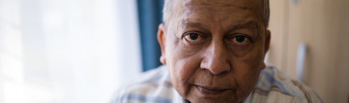 A close up of an elderly man 's face looking at the camera.