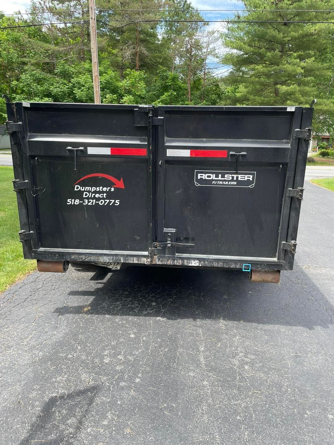 A dumpster is parked on the side of the road.