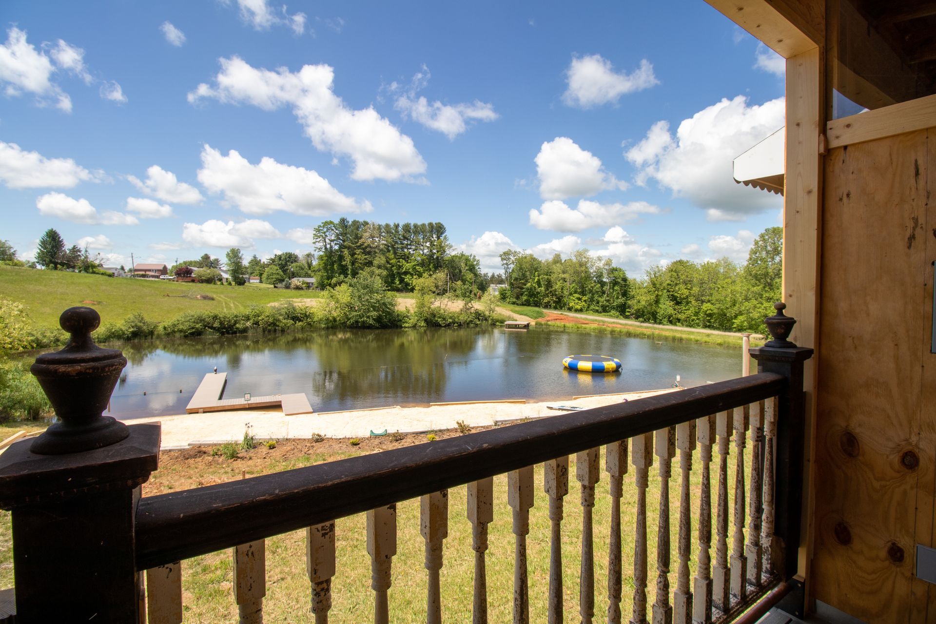 A view of a lake from a balcony with a raft in the water.