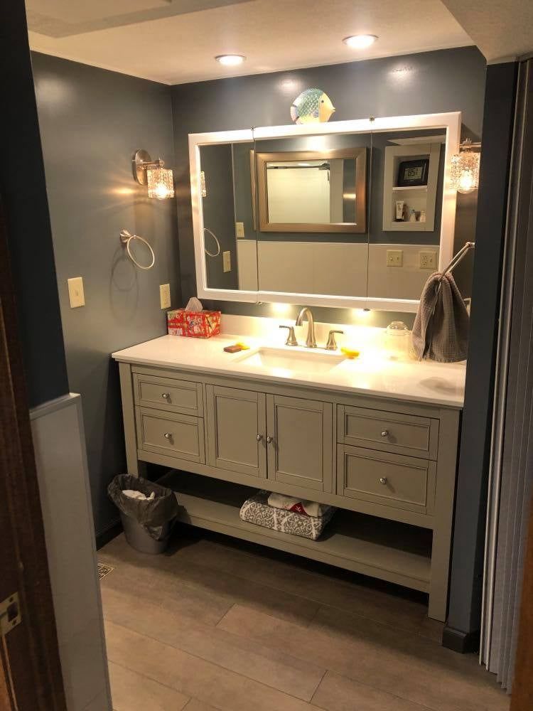 A bathroom with two sinks and a large mirror.