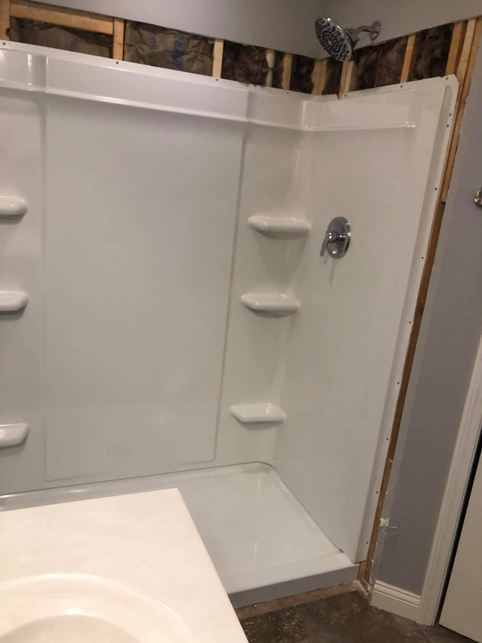 A bathroom with a shower stall and a sink.