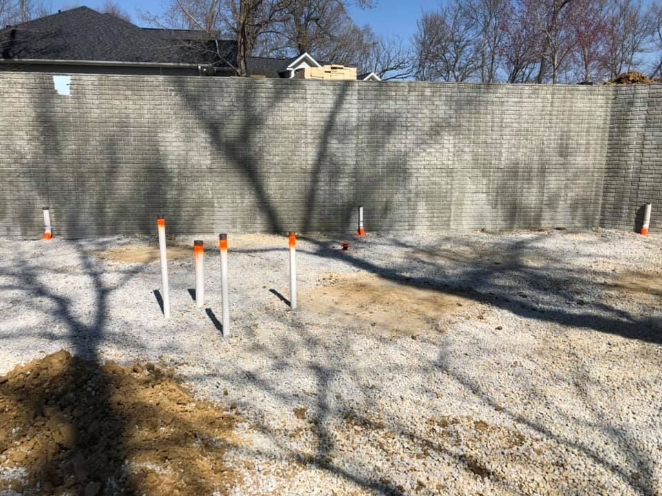 A concrete wall is being built next to a dirt field.