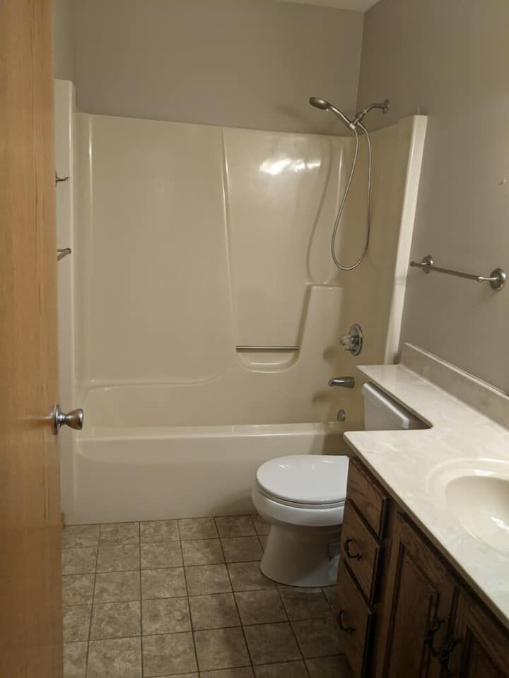 A bathroom with a tub , toilet , sink and shower.