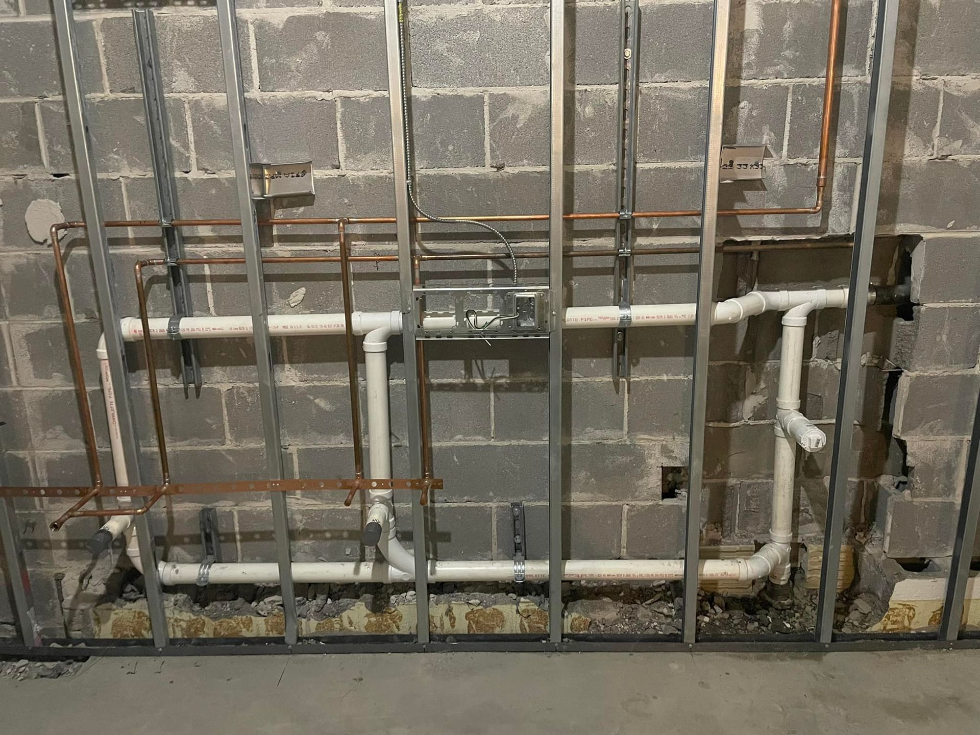 A brick wall with a lot of pipes coming out of it