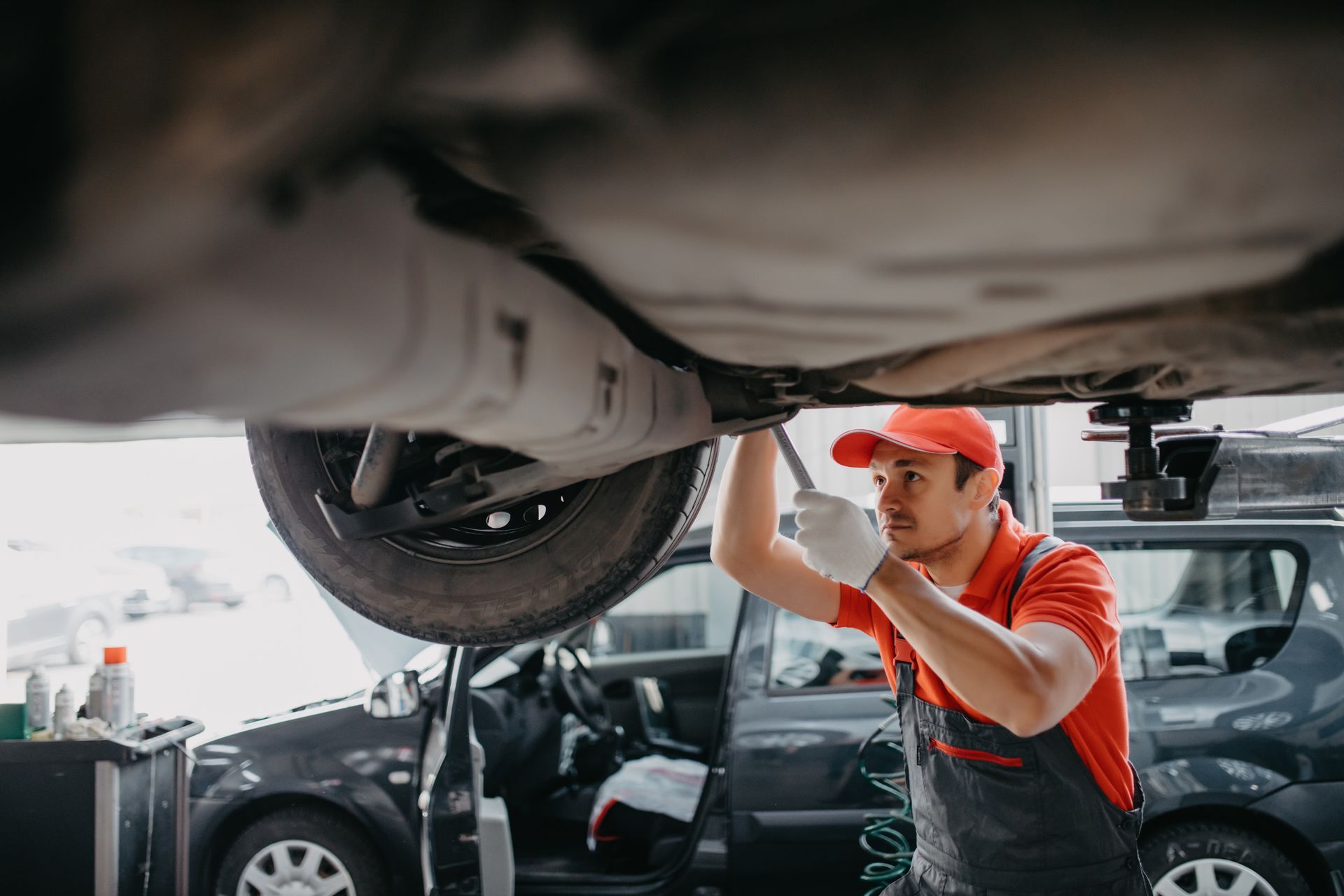 a man is working under a car with a wrench .