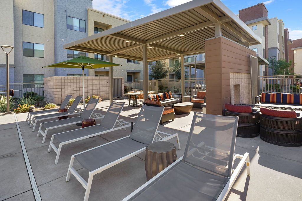 Outdoor communal lounge area with sun loungers and a shaded seating pavilion.