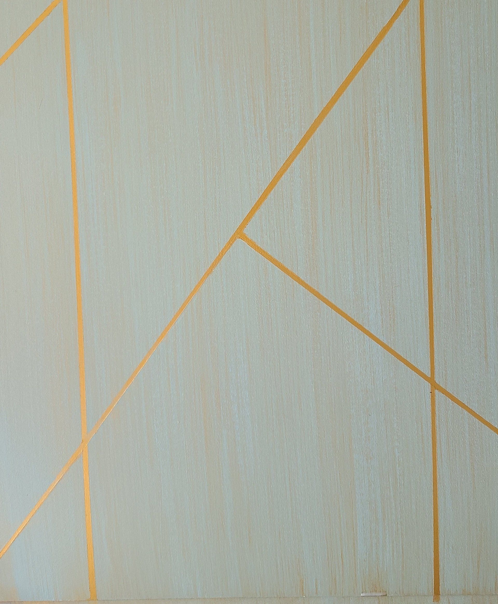 Gold lines against a light beige background, forming abstract geometric shapes.