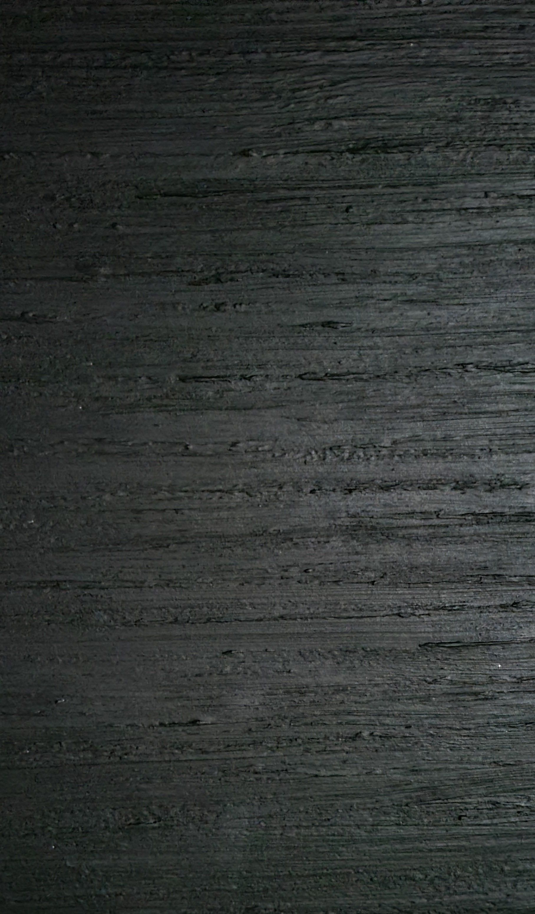 Dark wood grain texture, horizontal lines, varying shades of gray and black.