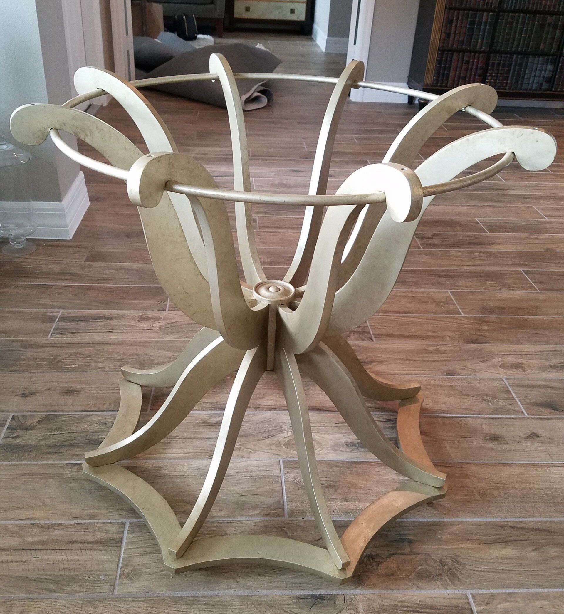 Gold-painted, ornate wooden pedestal table with curved supports and a round top.