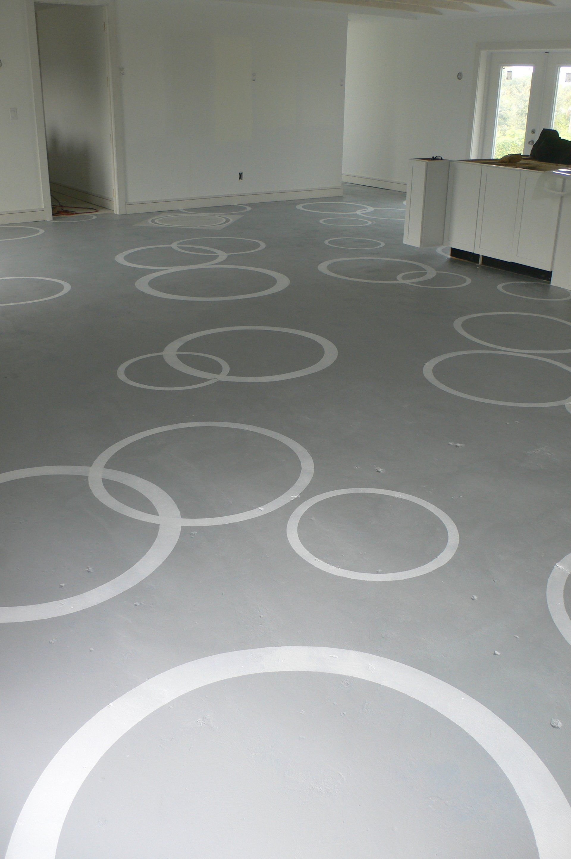 Gray floor with white overlapping circles in a mostly empty room, near an open doorway.