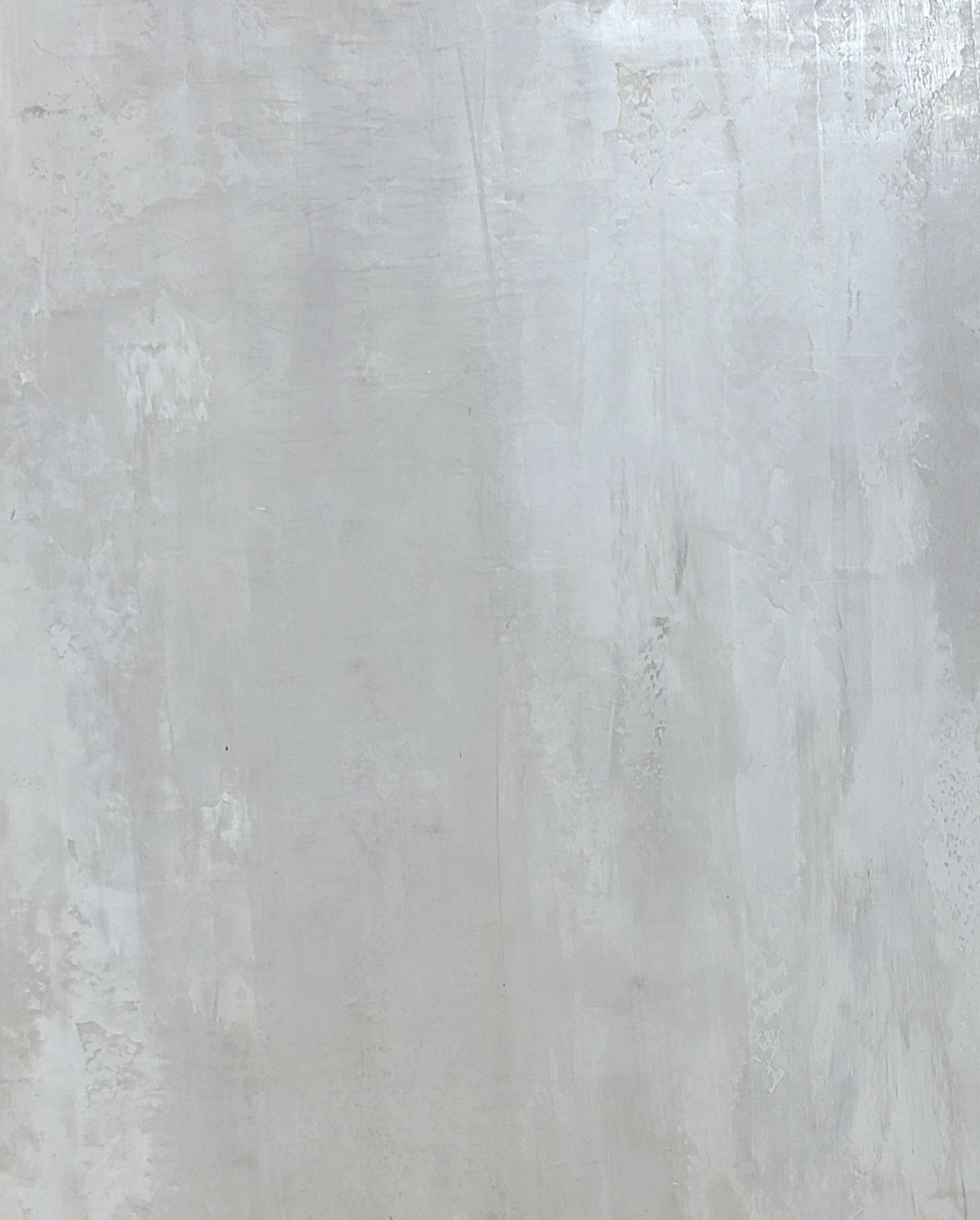 Gray wall with light and dark textured patches.