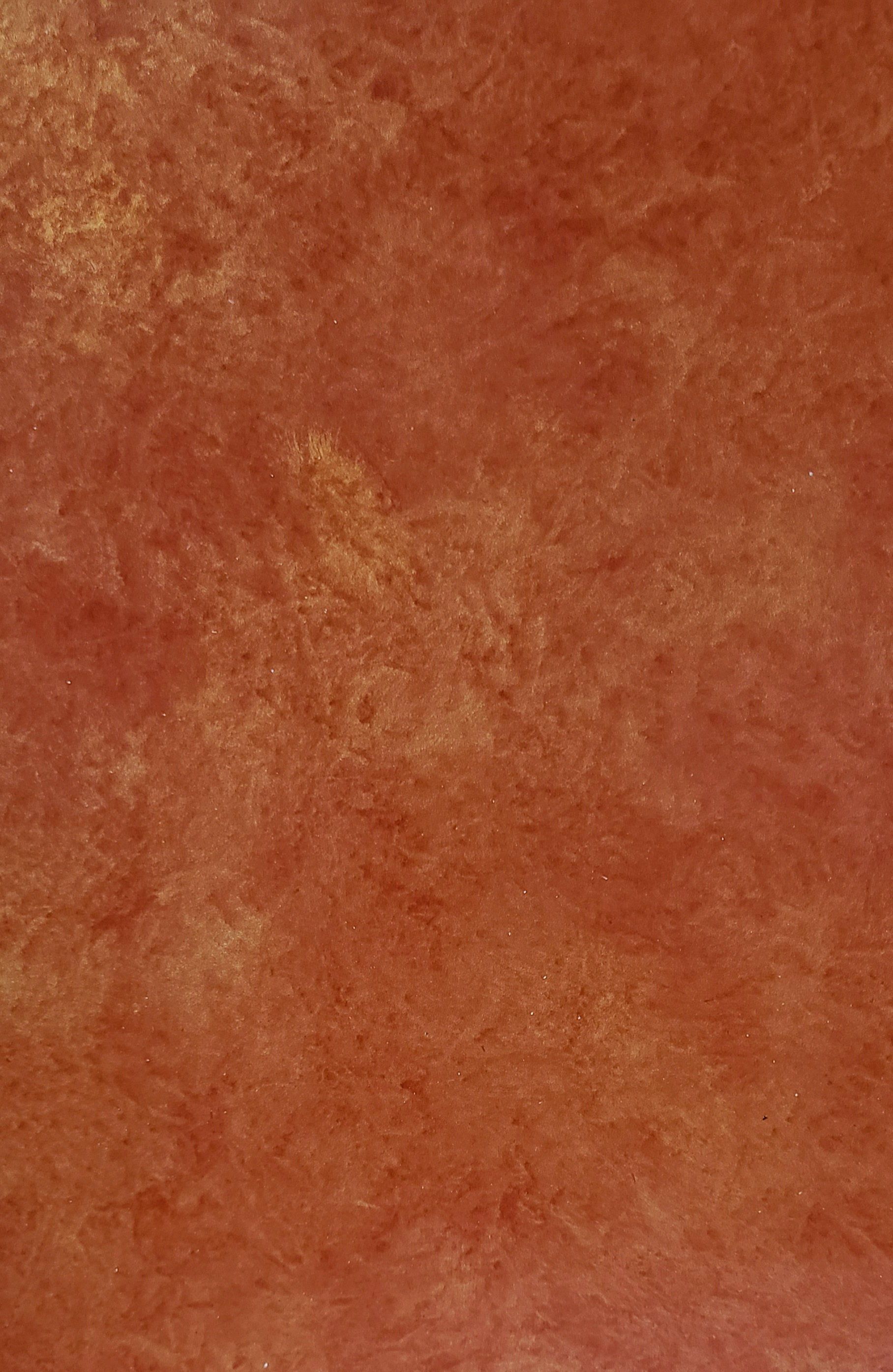 Textured wall with mottled shades of orange and gold.