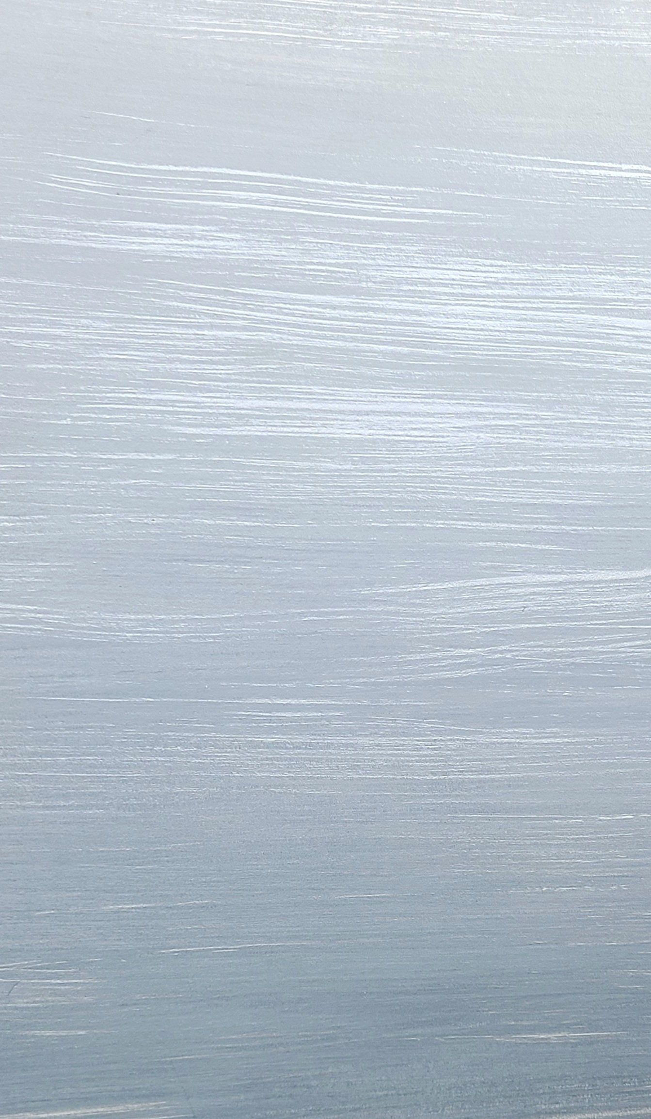 Water surface with subtle horizontal ripples, blue-gray hues, reflecting sunlight.