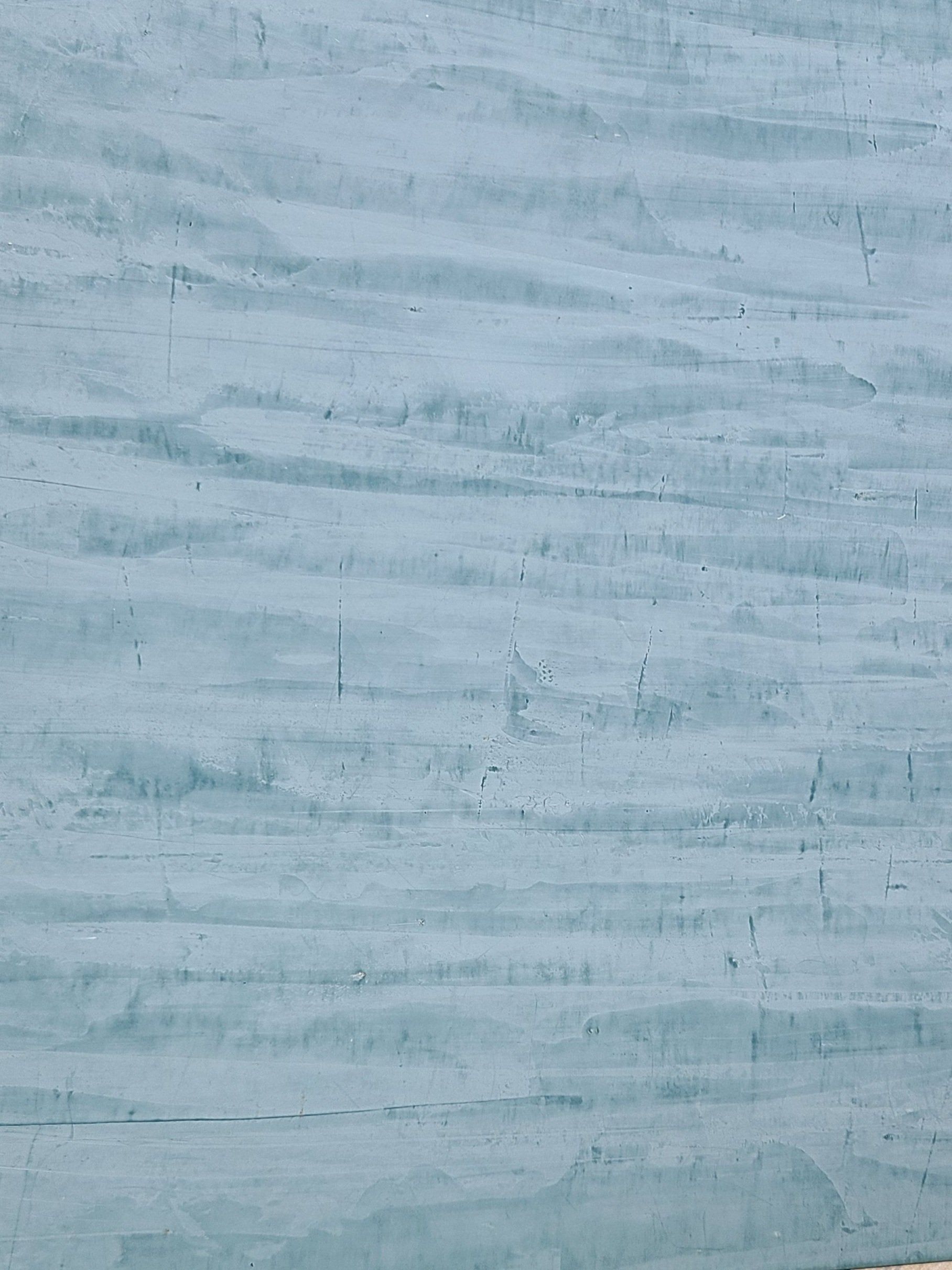 Blue-grey textured wall with horizontal strokes and slight waviness.