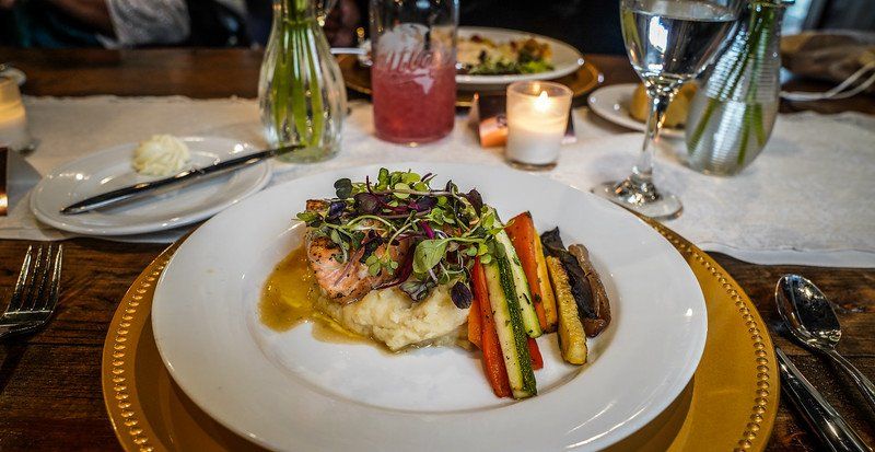A plate of food is sitting on a table next to a candle.