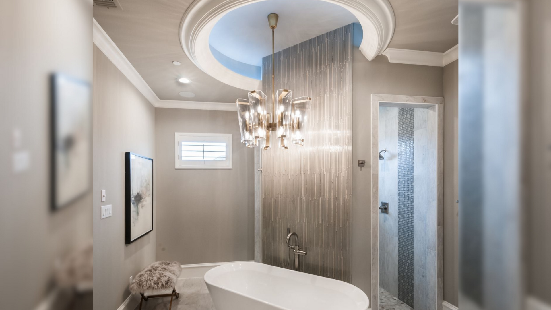 bathroom with a free standing tub with a chandelier hanging from the ceiling and a walk through shower