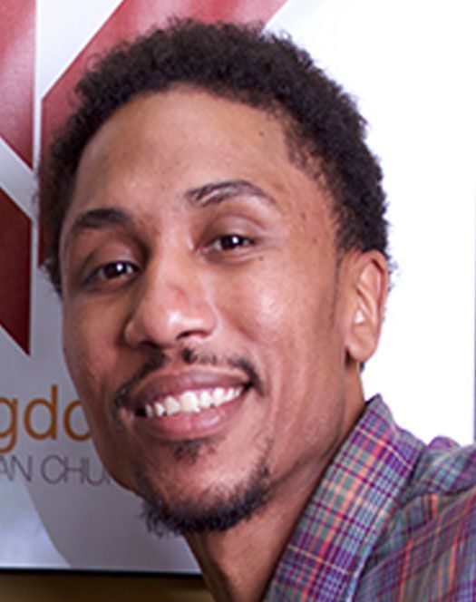 A man in a plaid shirt is smiling for the camera