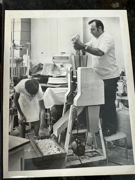 A black and white photo of two men working on a machine