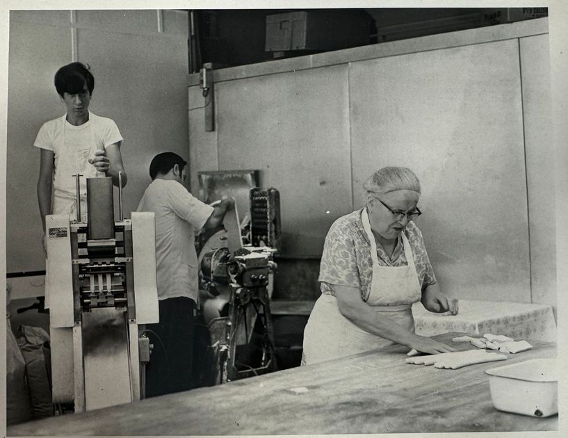 A black and white photo of people working in a kitchen