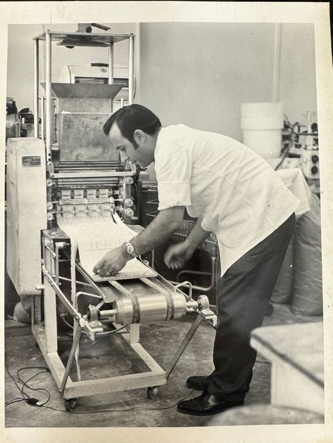 A black and white photo of a man working on a machine
