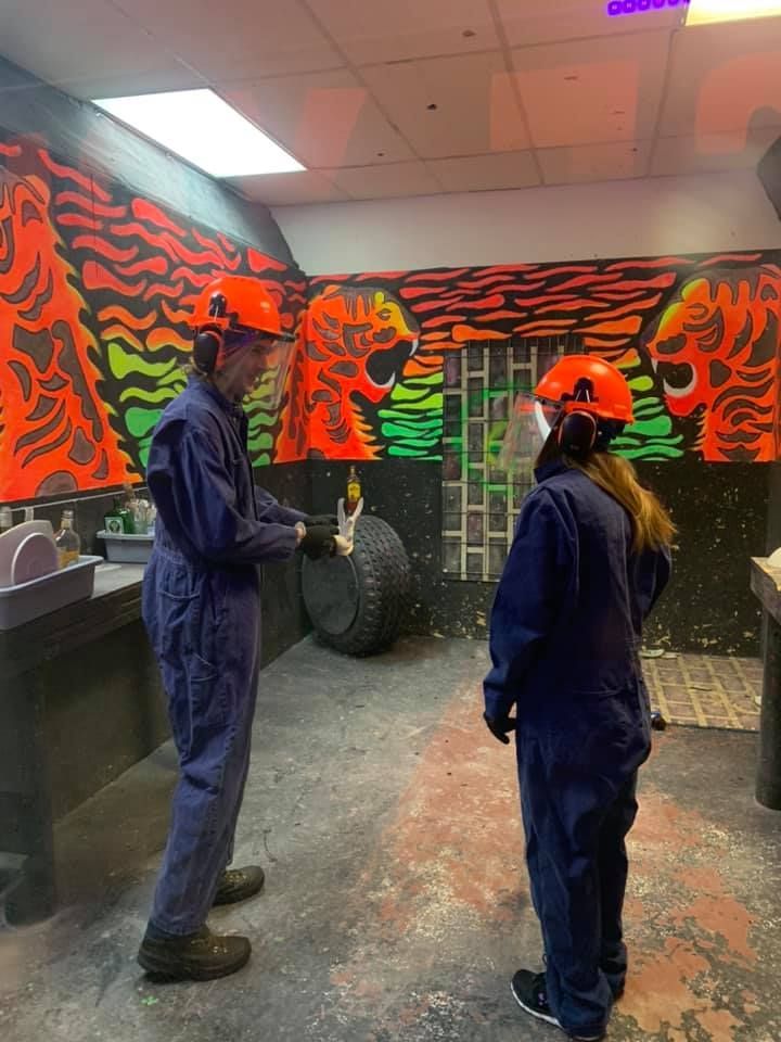 A man and a woman wearing hard hats are standing in a room.