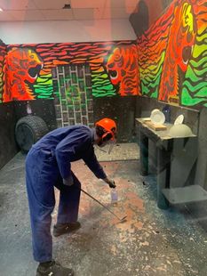 A man and a woman wearing hard hats are standing in a room.