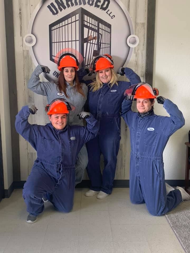 A group of people in blue jumpsuits and hard hats are posing for a picture.