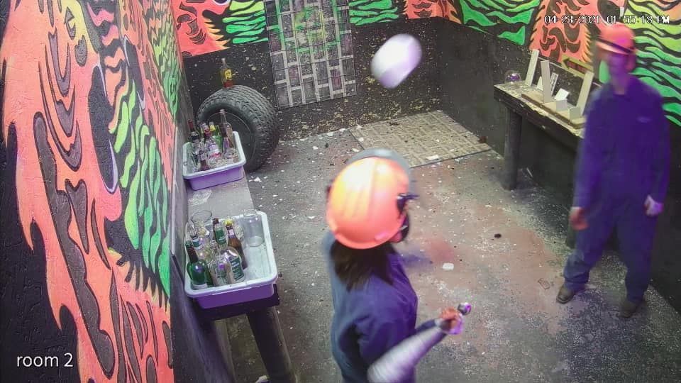 A man in a hard hat is throwing a ball in a room.