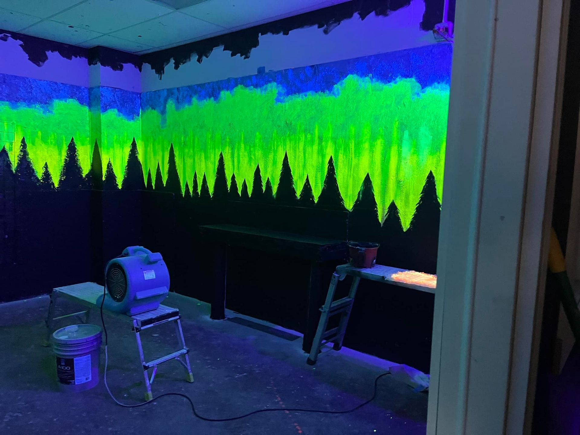 A room with a painting on the wall that glows in the dark.