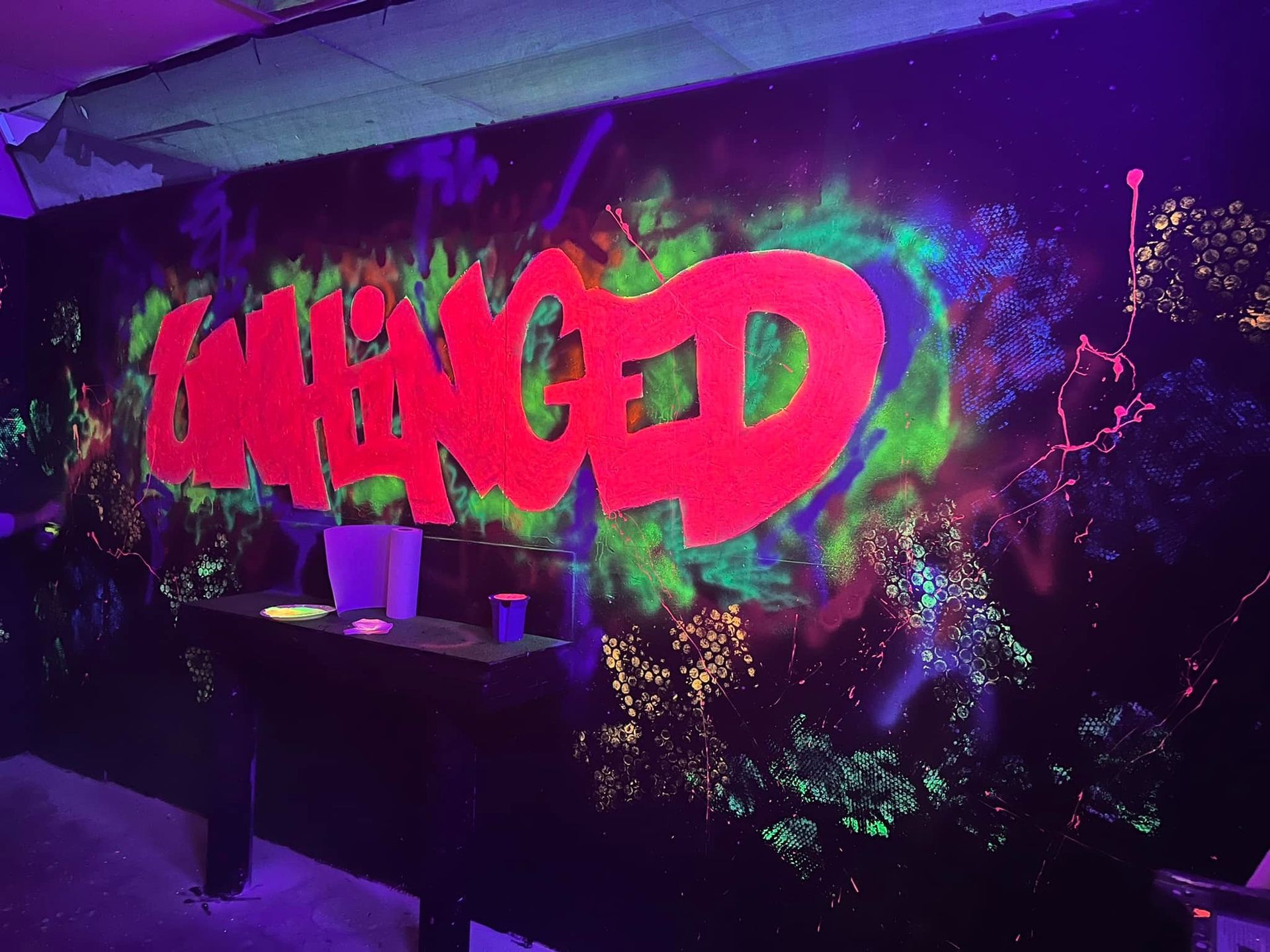 A glow in the dark wall with the word damaged painted on it