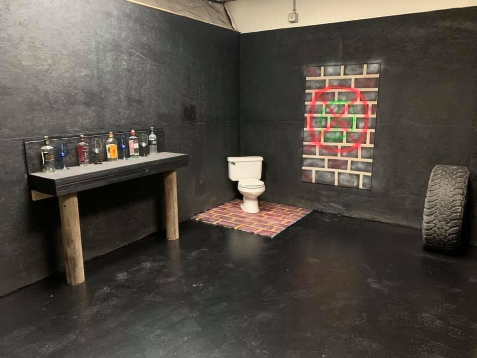 A bathroom with a toilet , table , and tire.