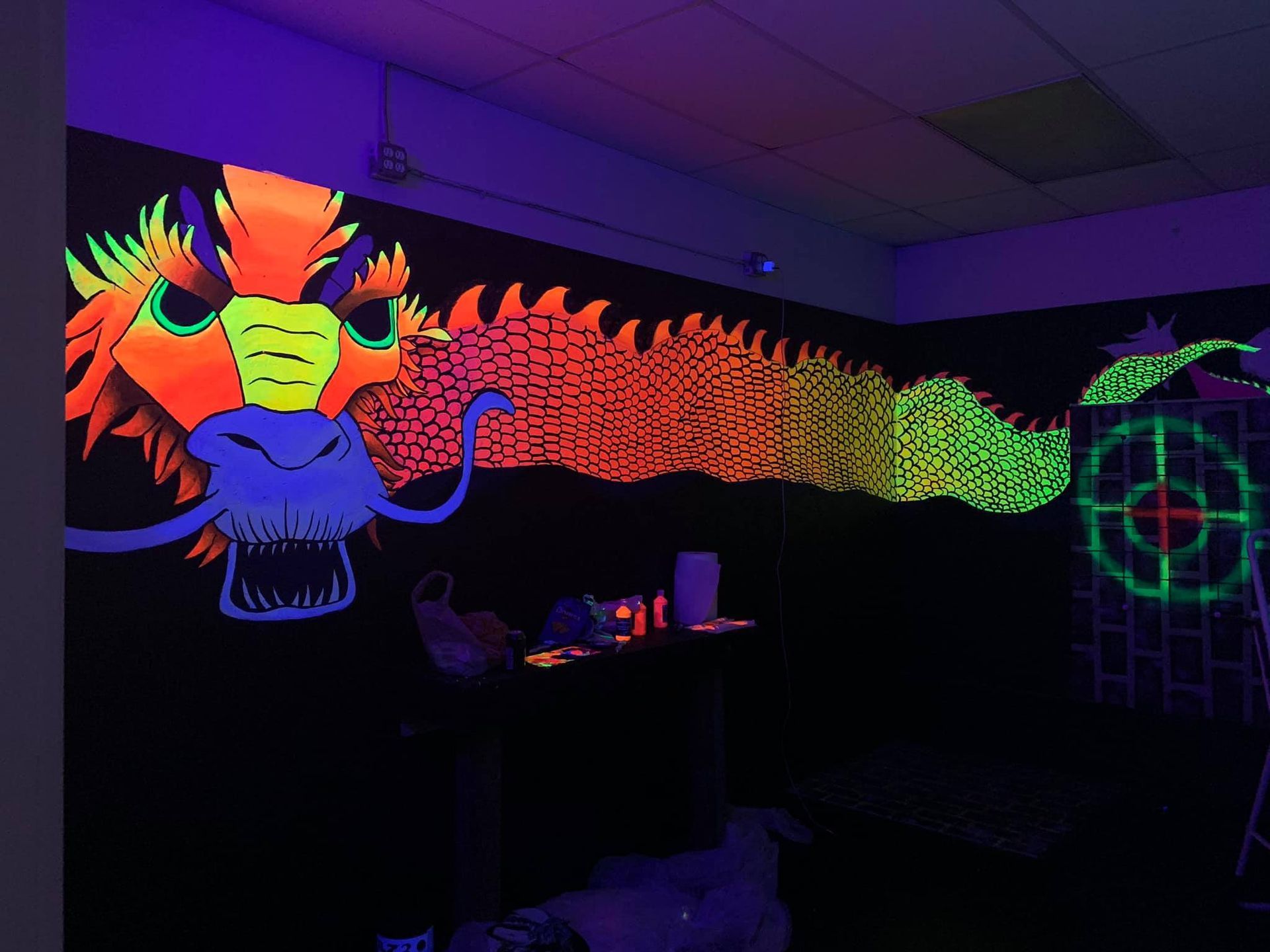 A glow in the dark painting of a dragon on a wall