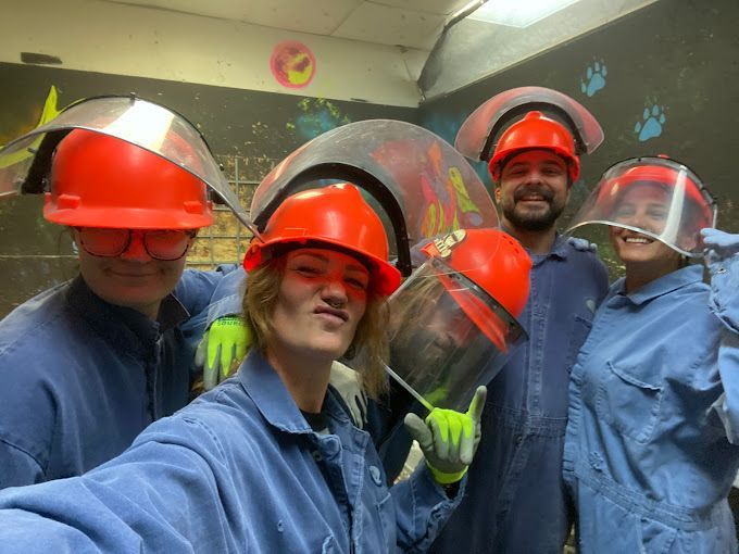 A group of people wearing hard hats and face shields