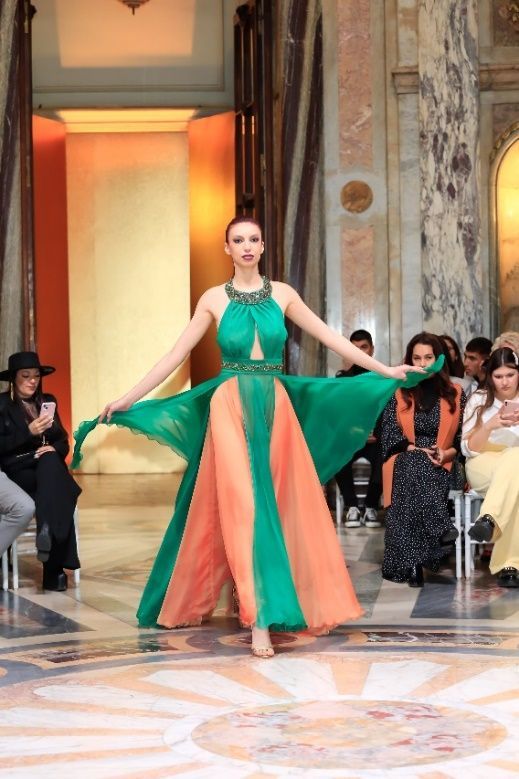 Una mujer con un vestido morado está parada en un conjunto de escaleras.