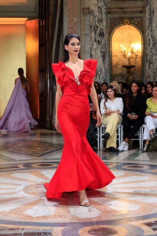 Una mujer con un vestido morado está parada en un conjunto de escaleras.