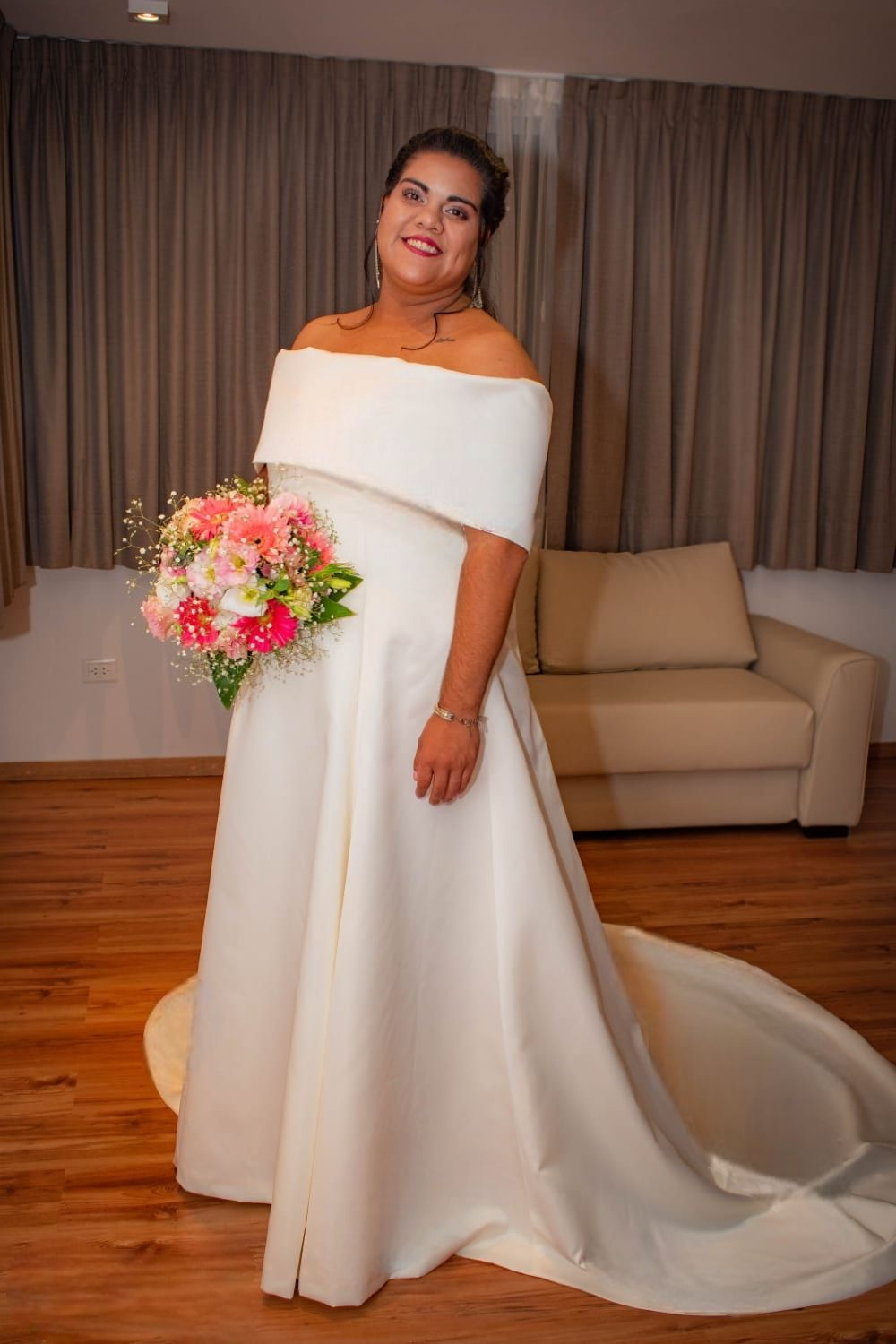 La novia lleva un vestido de novia blanco y sostiene un ramo de flores.