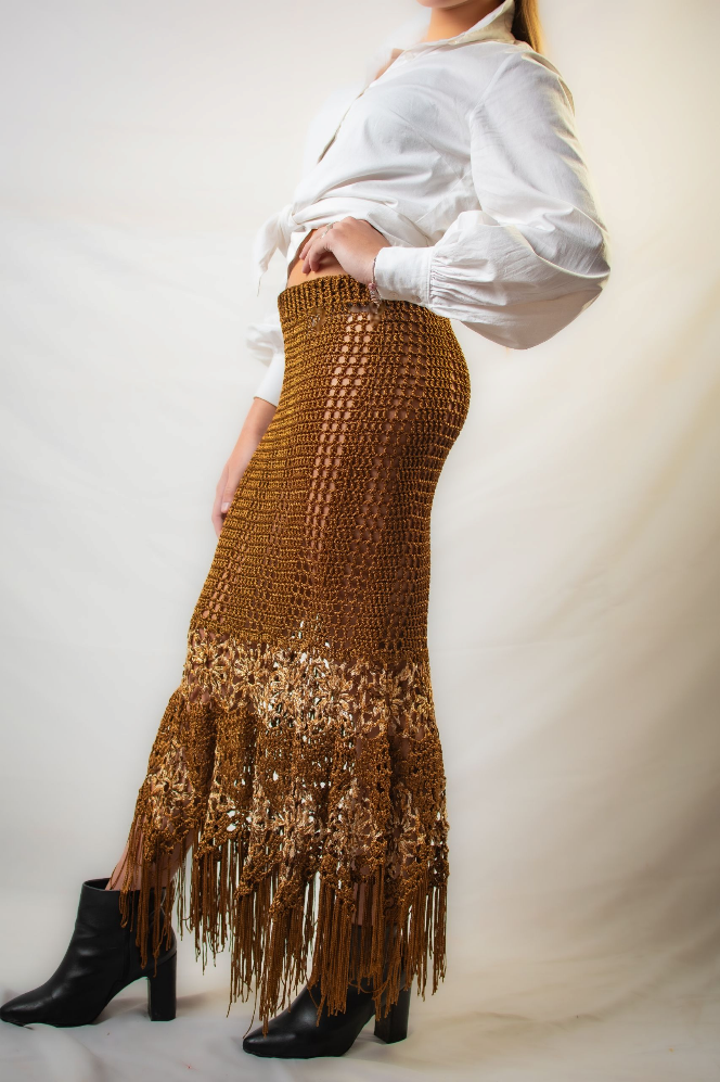 torso de mujer de perfil con blusa blanca y pollera marron tejida en crochet