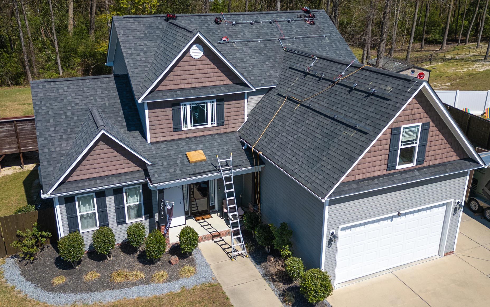 An aerial view of a house with solar panels on the roof.