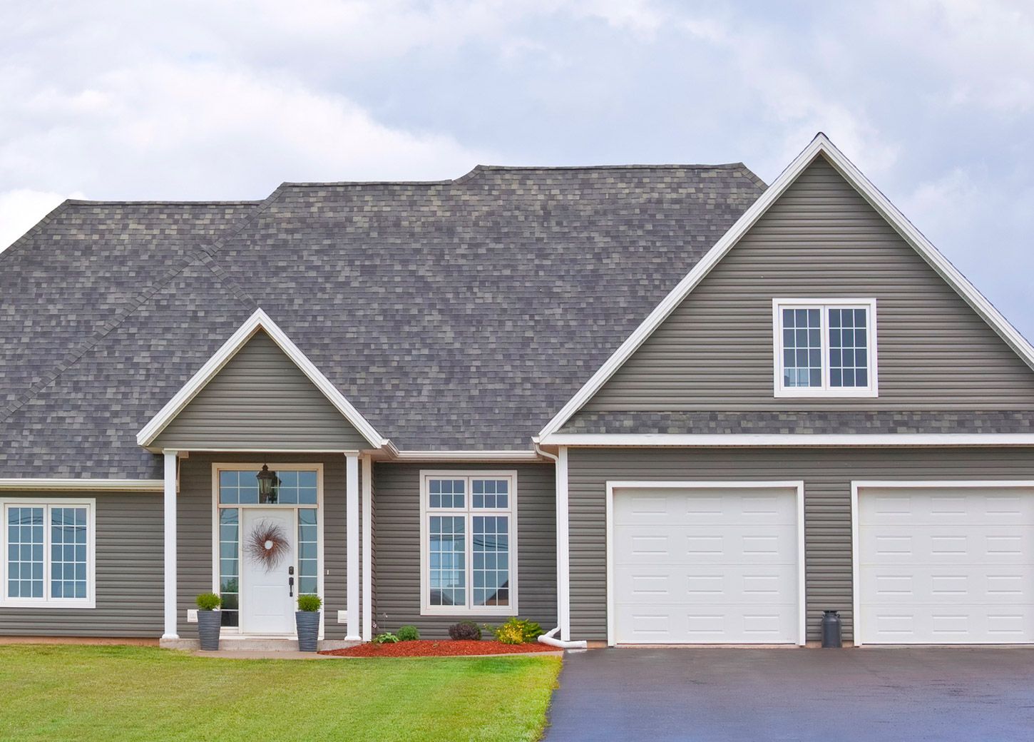 A gray house with white trim and a gray roof