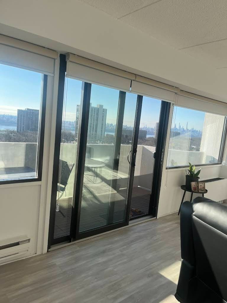 A living room with a lot of windows and a view of the city.